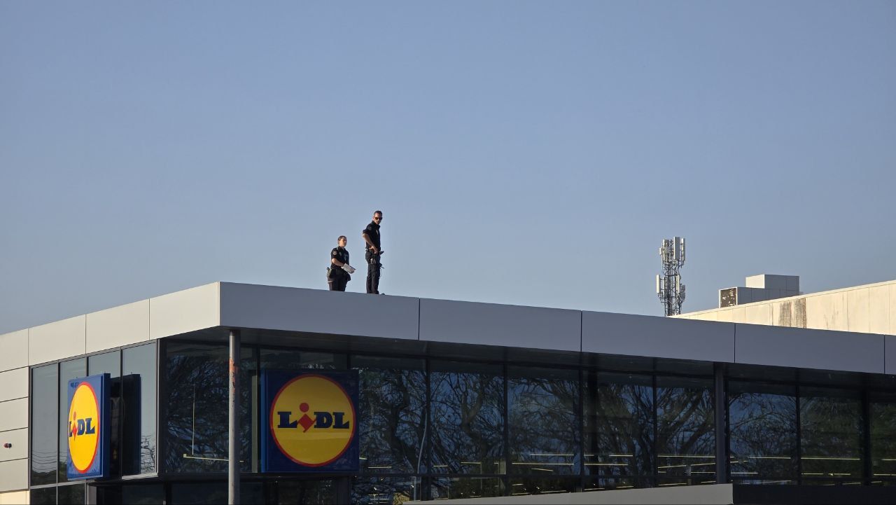Dos agentes de la Policía Nacional, en lo alto del techo del Lidl.
