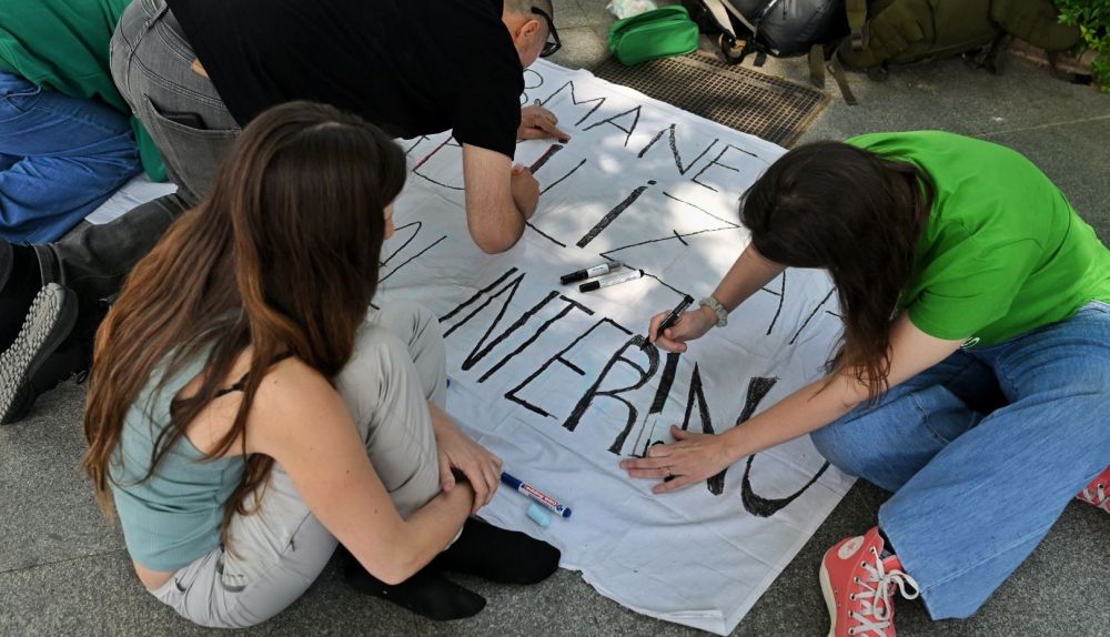 Docentes interinos preparando una pancarta.