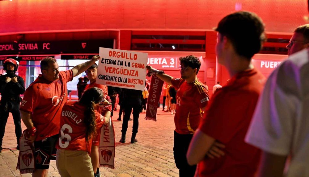 Aficionados sevillistas, con una pancarta.