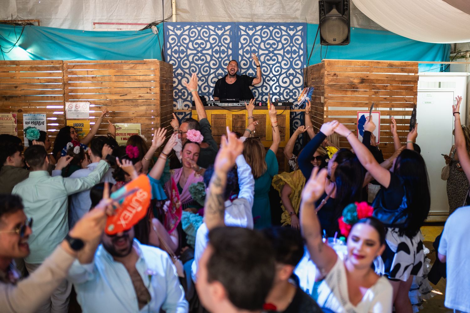Un grupo de jóvenes baila bajo la dirección de un dj en una caseta del real.