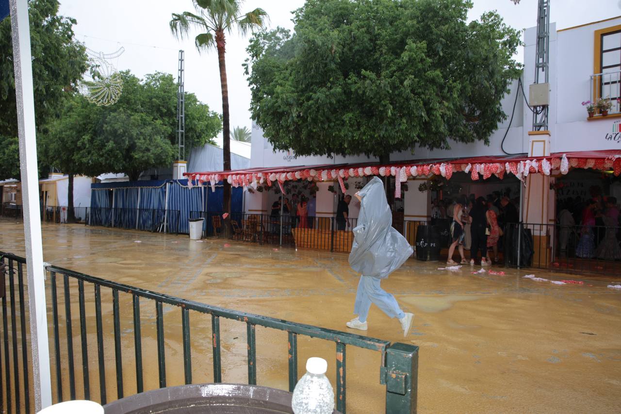 Una chica, con un chubasquero improvisado en la Feria de Jerez durante las lluvias.