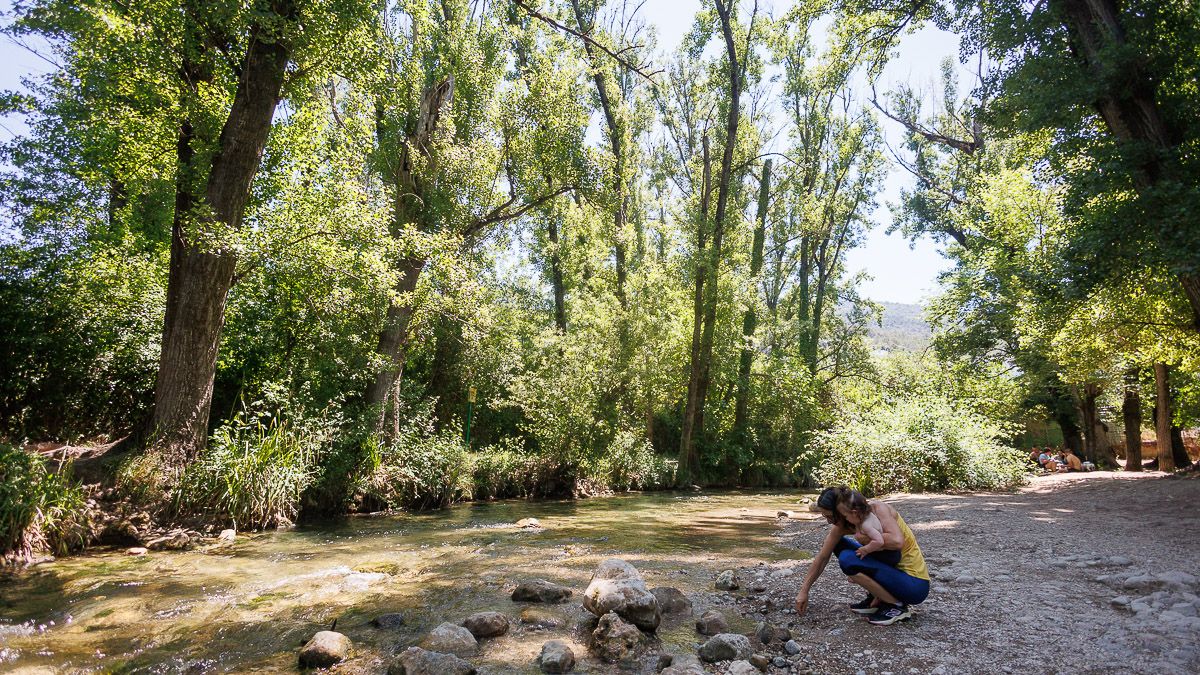 Una madre se refresca con su hija en el río Majaceite, en el Parque Natural Sierra de Grazalema.