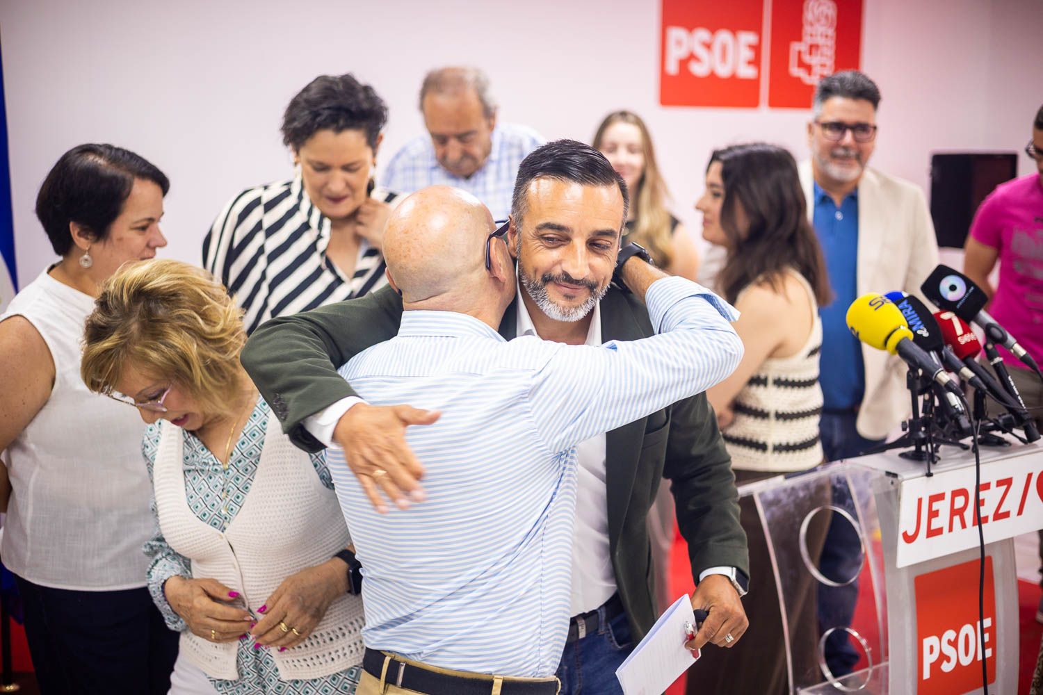 José Antonio Díaz, tras la rueda de prensa, abrazado por sus compañeros de candidatura —en este caso, José Manuel Jiménez—, este miércoles en la sede del PSOE de Jerez.