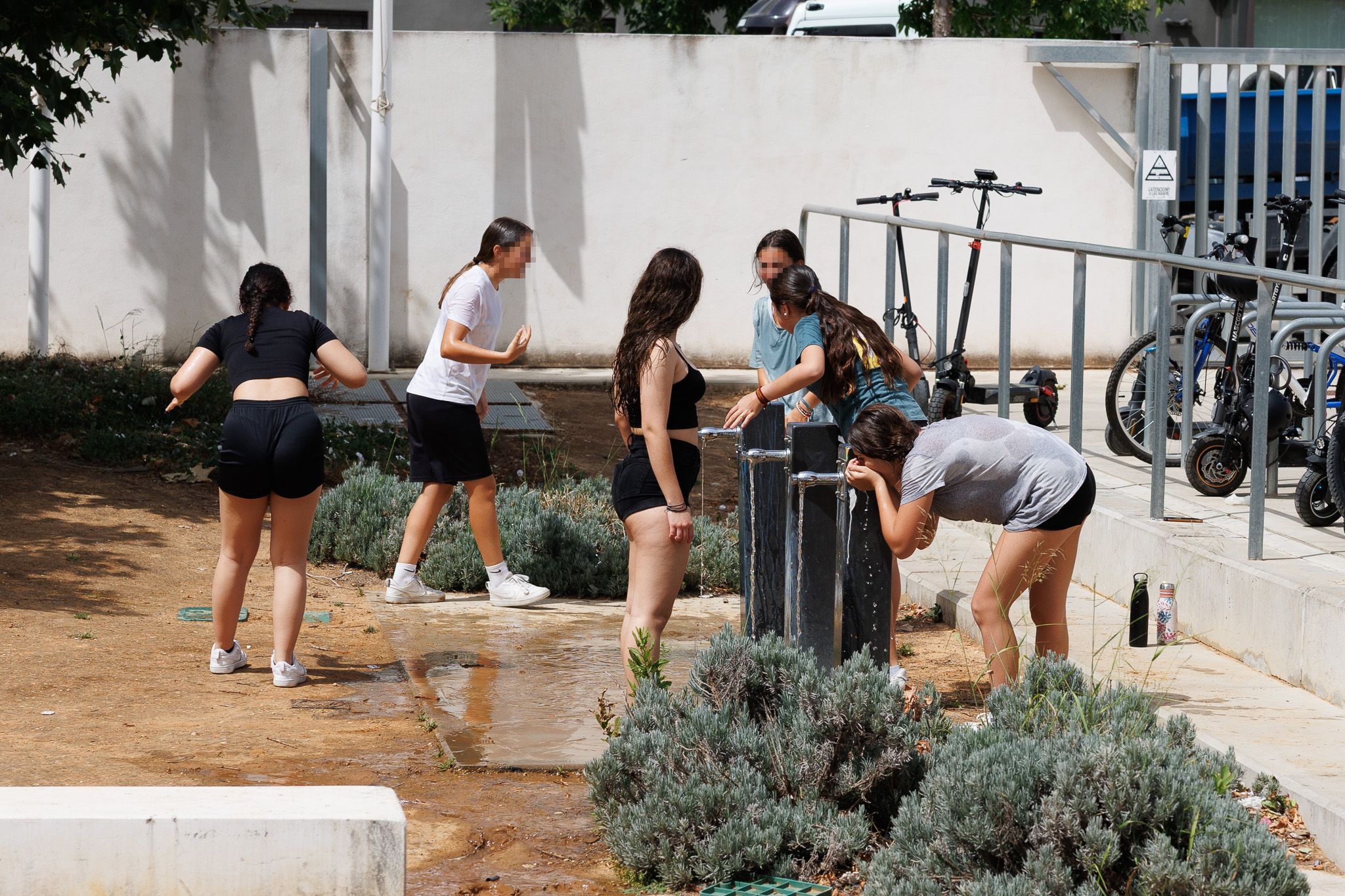 Unas niñas se refrescan este viernes en el IES Elena García Armada de Jerez.