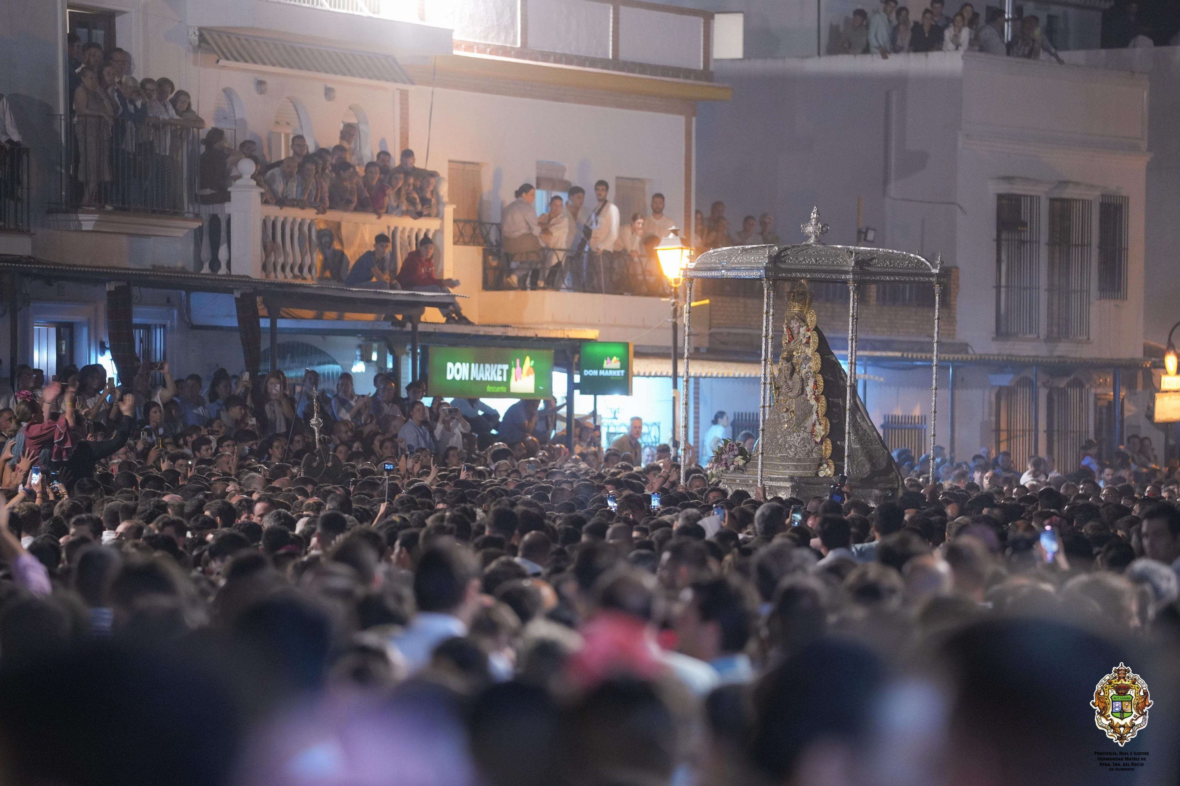La procesión de la Virgen del Rocío, en la calle Real de la aldea, entre multitudes.