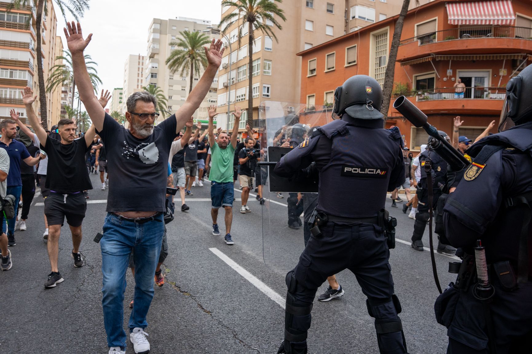 Manifestante avanza por la avenida principal al paso junto al cordón policial durante la movilización del sector del metal