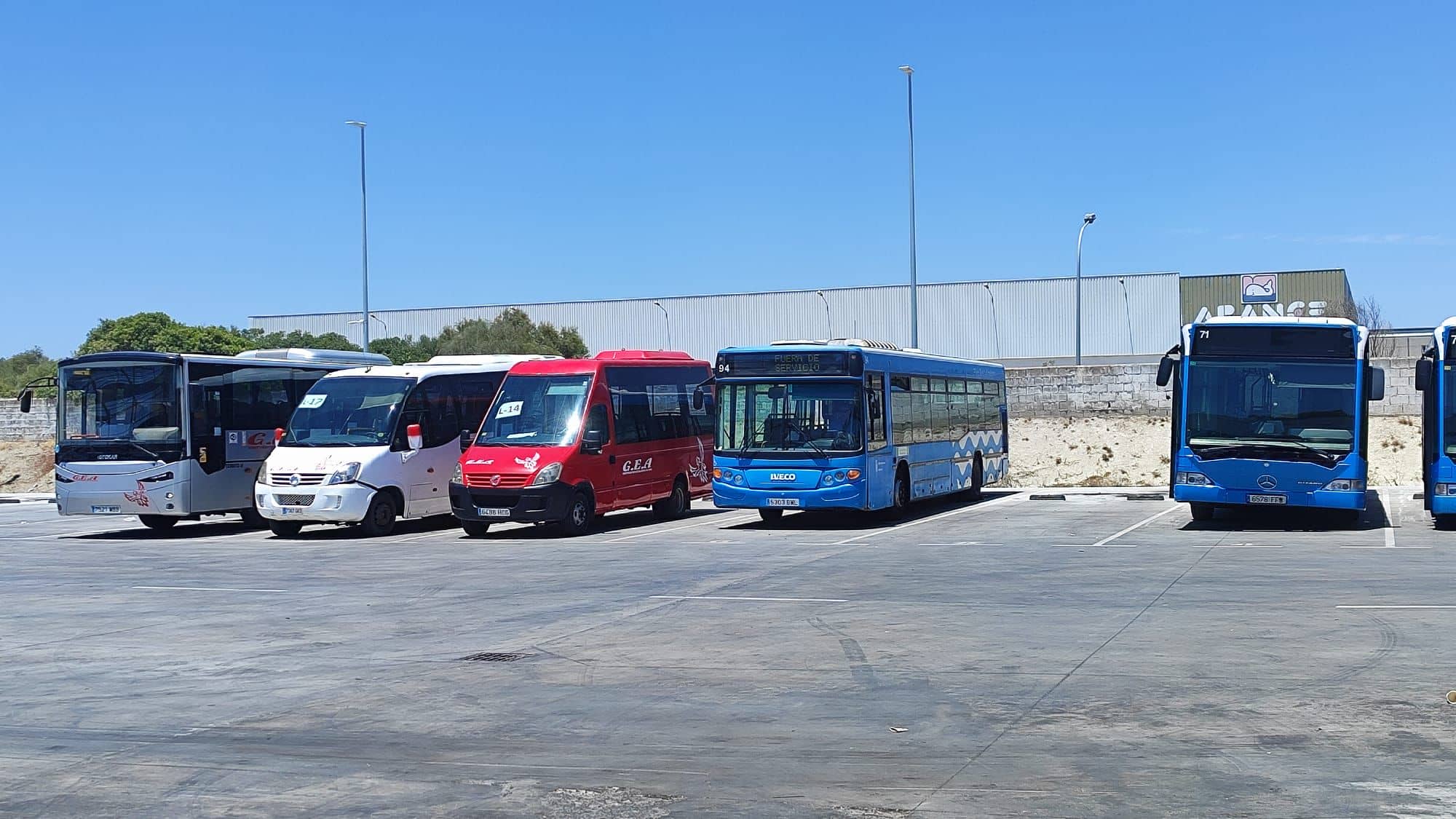 Los dos microbuses, de rojo y de blanco, en las cocheras.