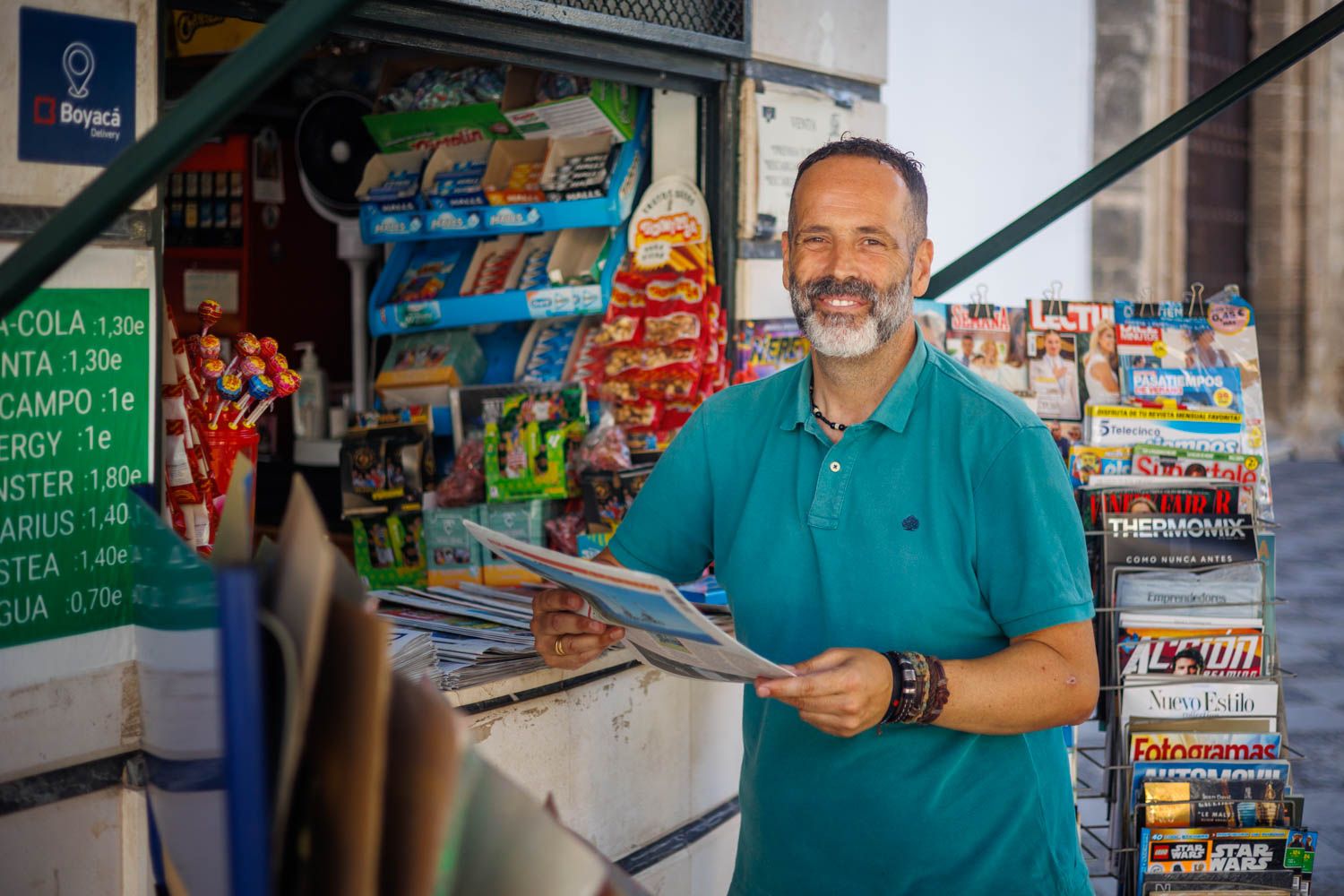 Jesús Gómez ante el expositor de revistas del kiosco. 