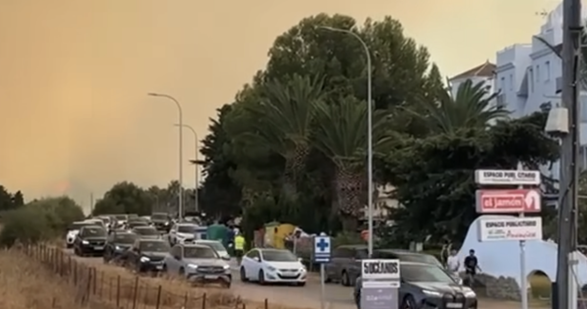Coches saliendo de Atlanterra por el incendio forestal de este lunes.