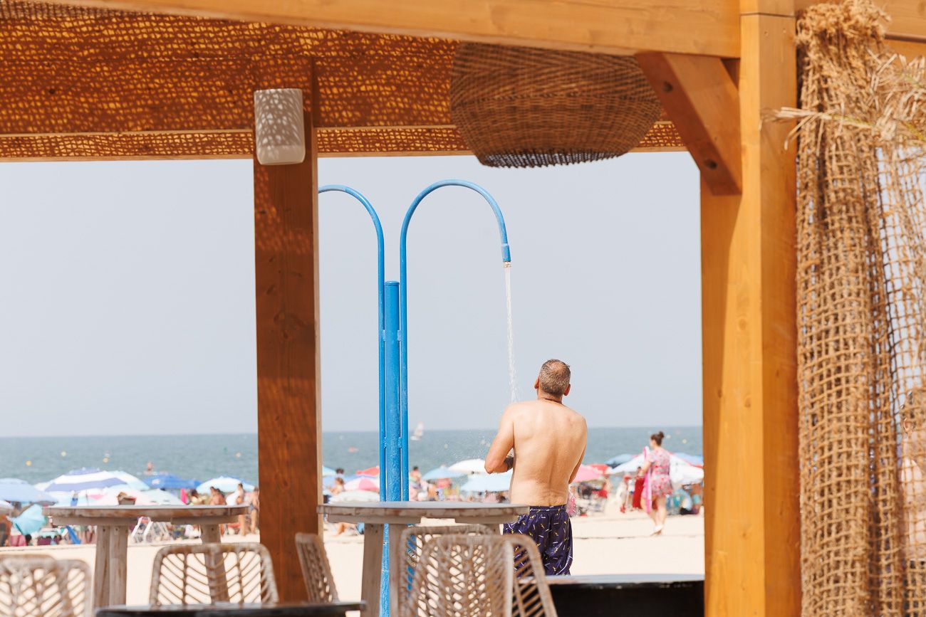 Un hombre se ducha en una playa de Rota, este lunes, día final de la ola de calor.
