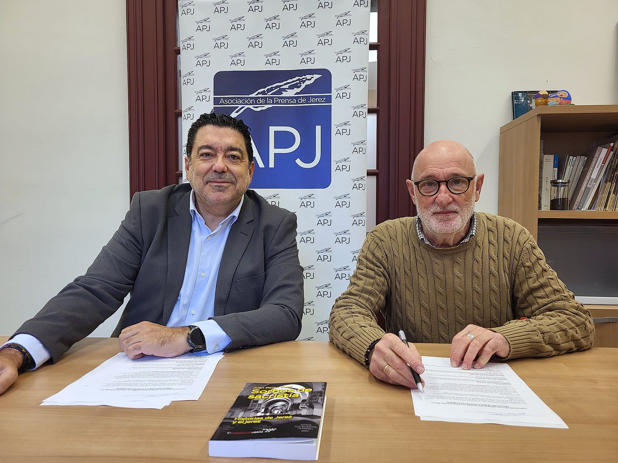 El presidente de la APJ y el gerente de Peripecias Libros en la firma del convenio.