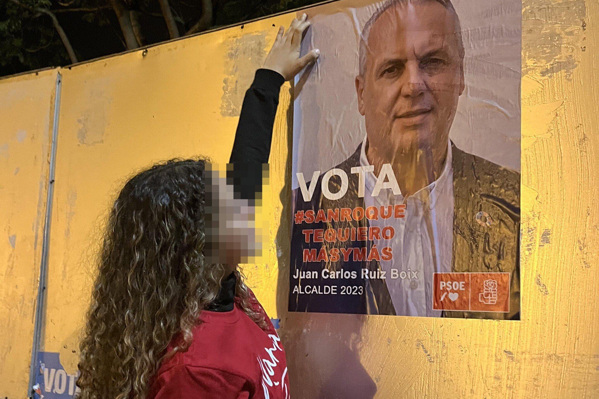 La hija de Juan Carlos Ruiz Boix ante un cartel electoral de su padre como candidato socialista.