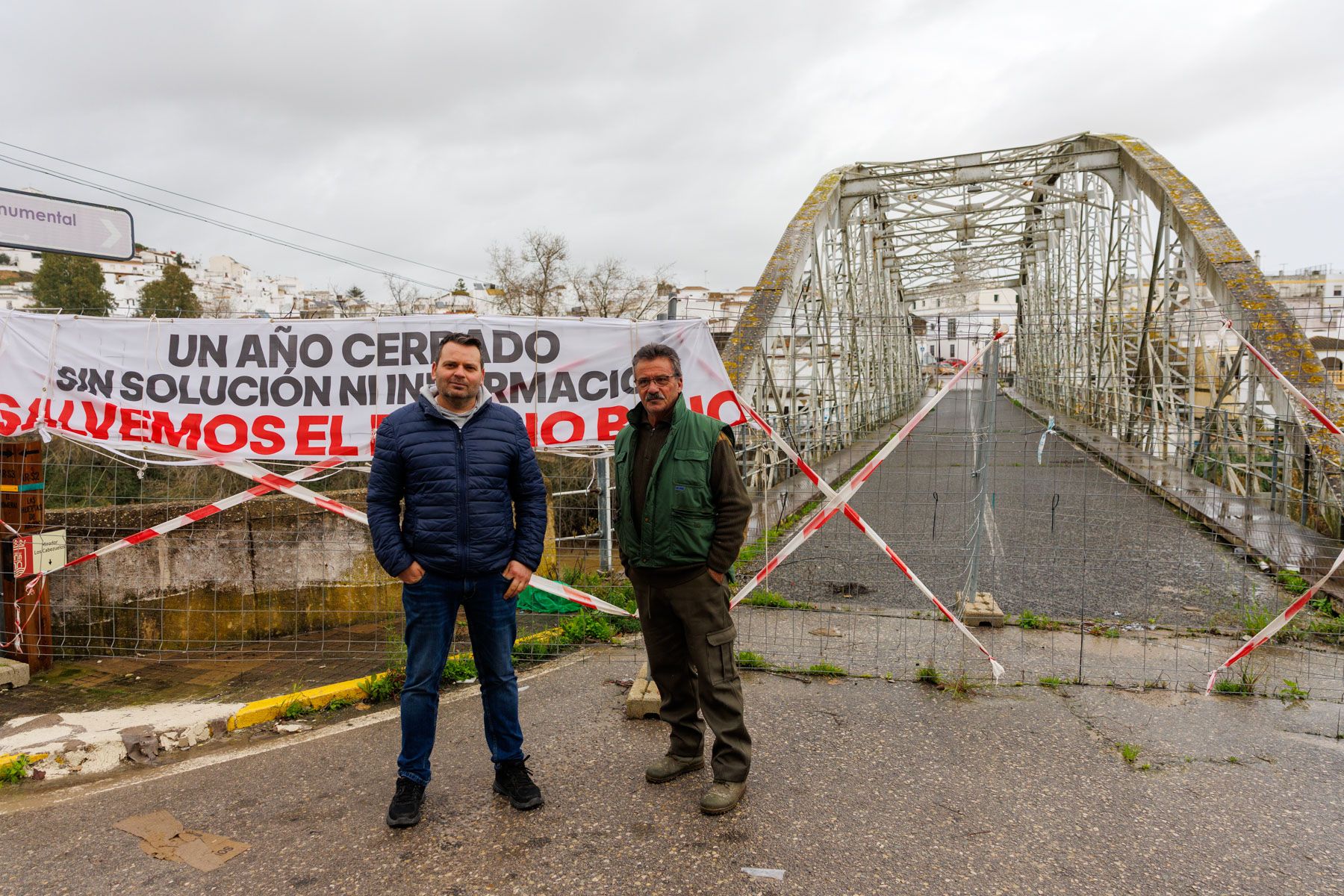 El ferretero Javier Ballesteros y Bartolomé González, vecino del Barrio Bajo de Arcos, con el puente de San Miguel al fondo.