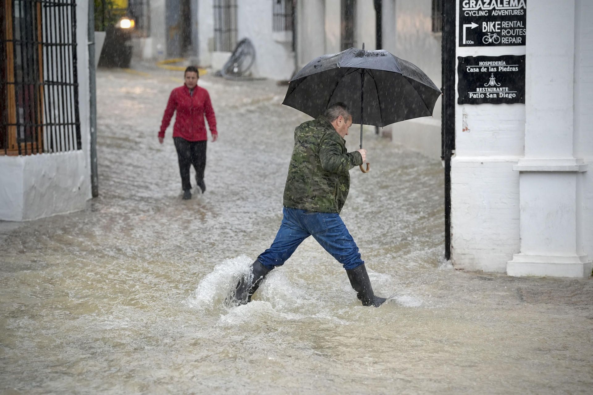 Un vecino cruza una calle anegada por las lluvias en Grazalema.