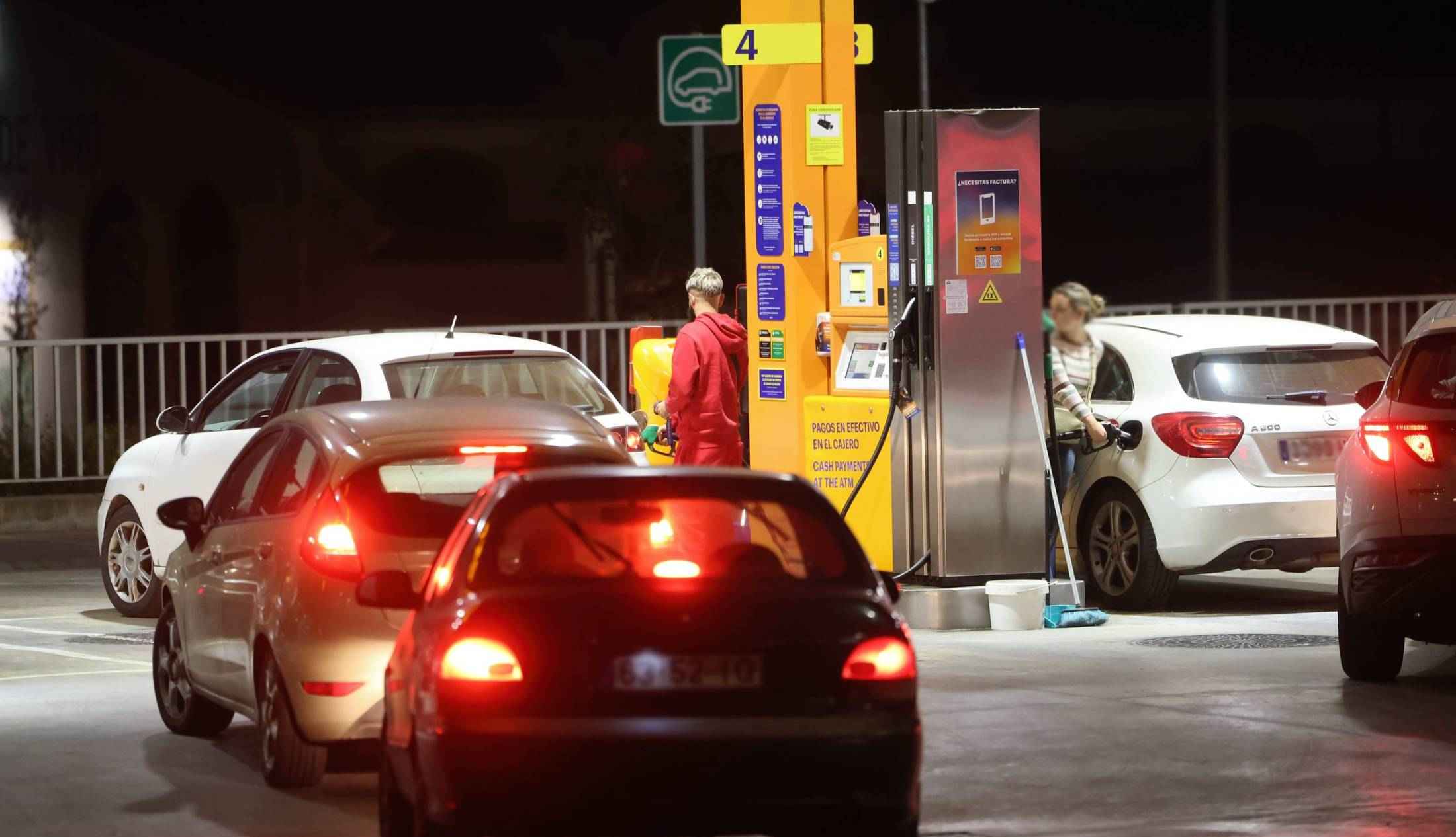 Personas repostando esta noche en una gasolinera en Jerez.