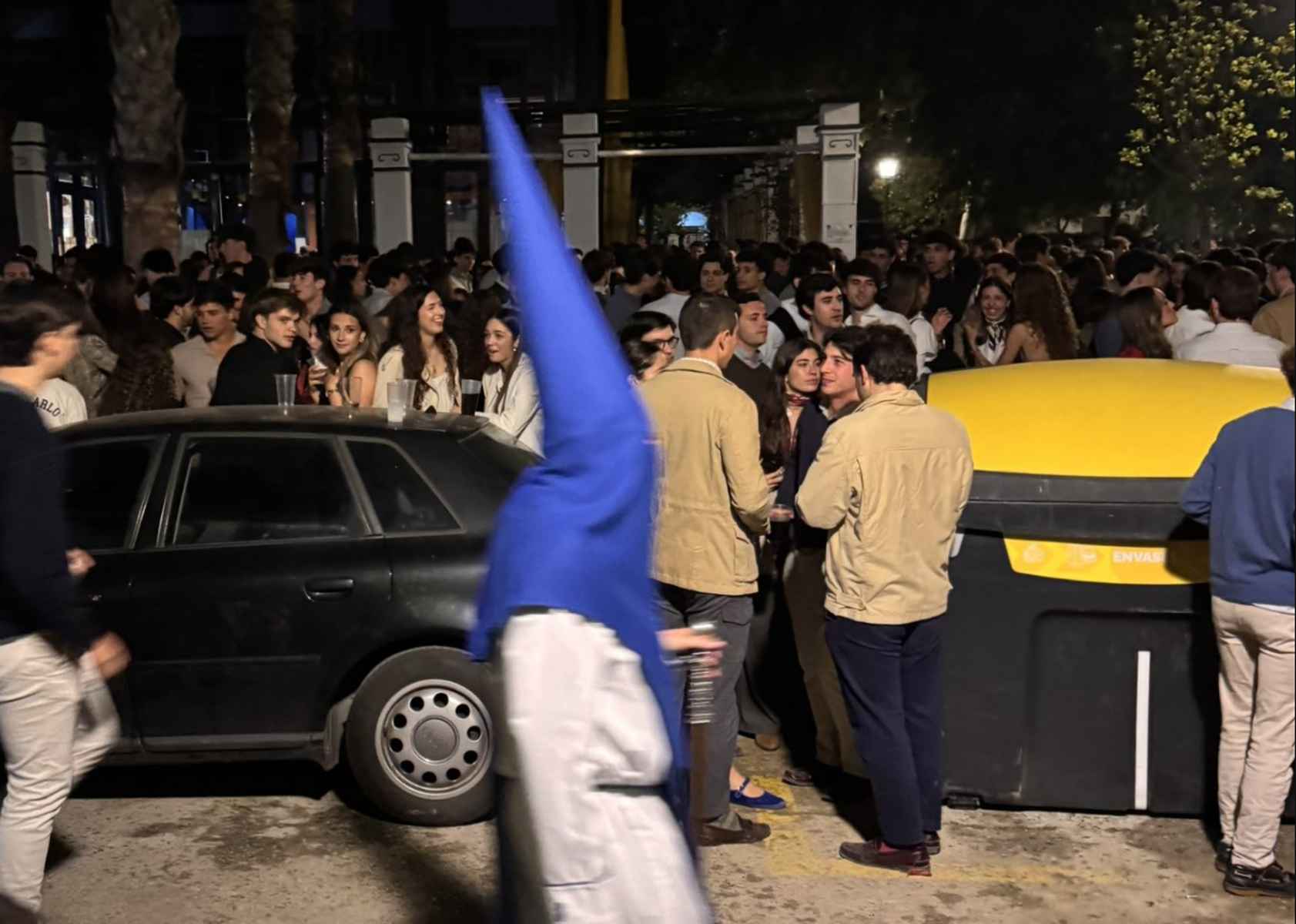 Un nazareno de La Misión, con jóvenes al fondo.