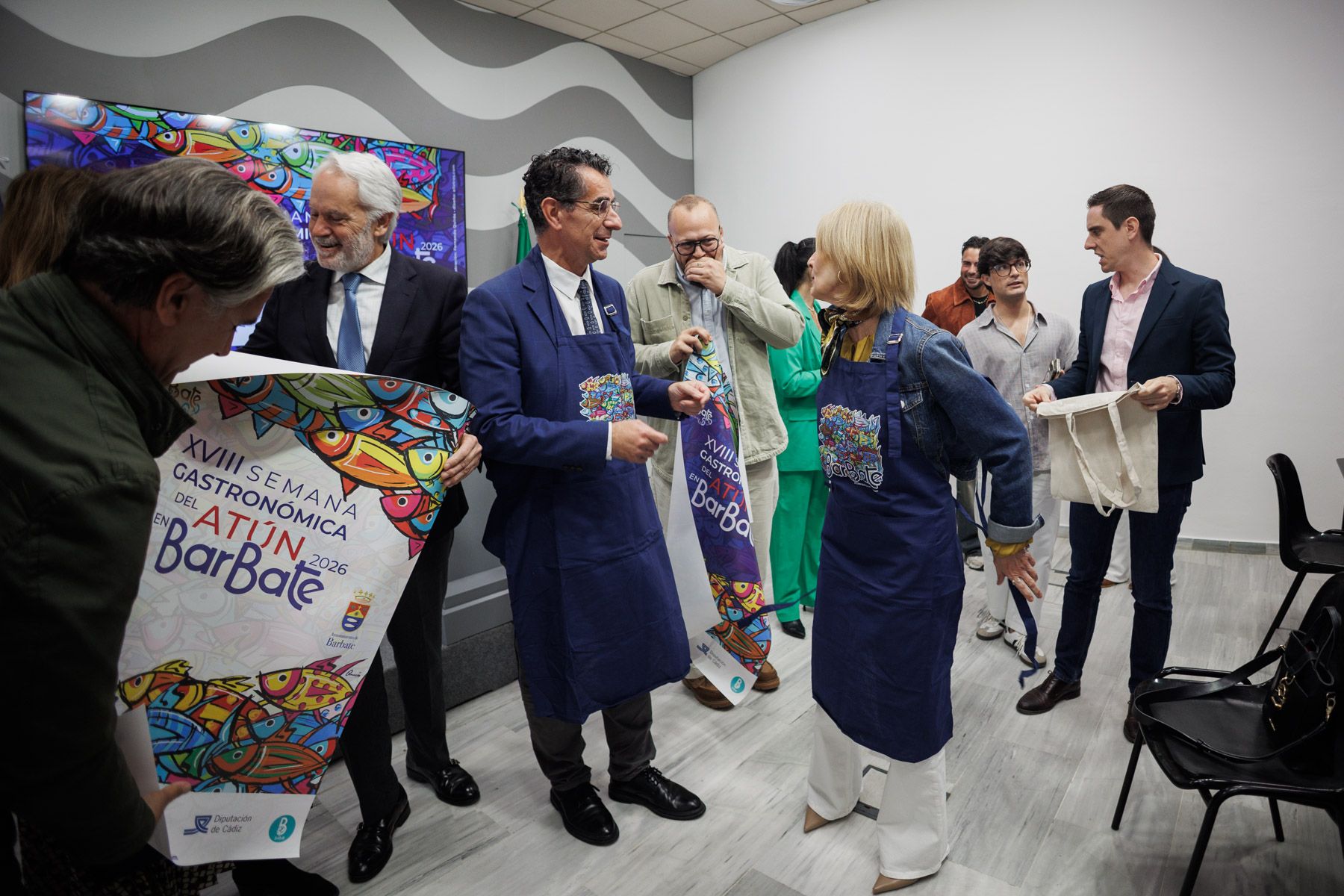 Los alcaldes Molina y Pelayo se ponen unos delantales de promoción de la Semana del Atún barbateña en el Ayuntamiento de Jerez.