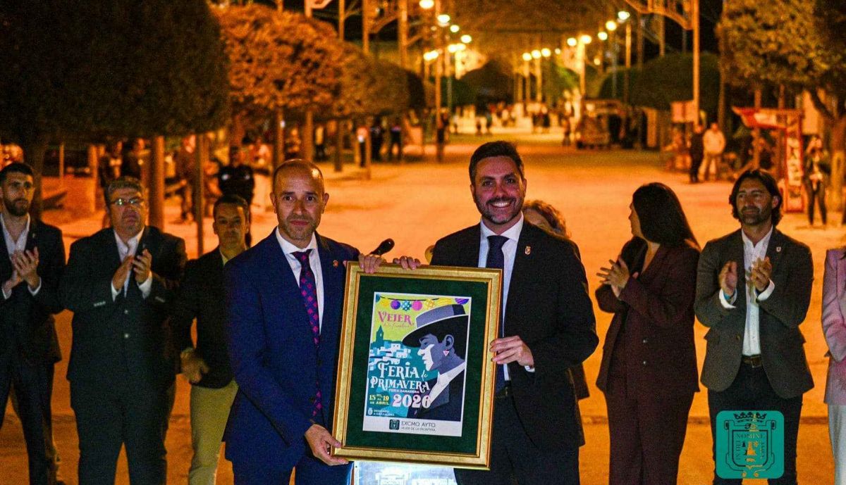 Antonio González, alcalde de Vejer, entregando un cartel de la Feria de Primavera a Carlos Javier García, alcalde de Grazalema.