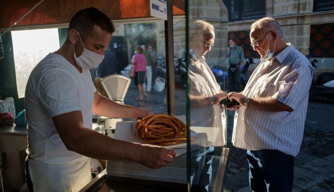 Antonio Padilla, en su puesto de churros con Pepe, uno de sus habituales.