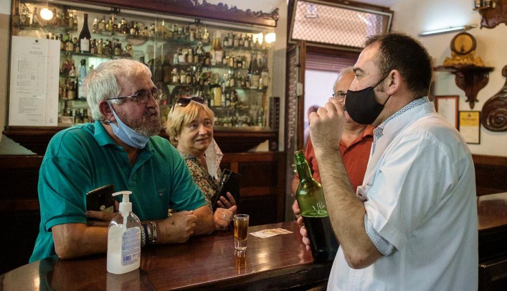 El regente de La Manzanilla conversa, en días pasados, con dos clientes. Autor: Manu García
