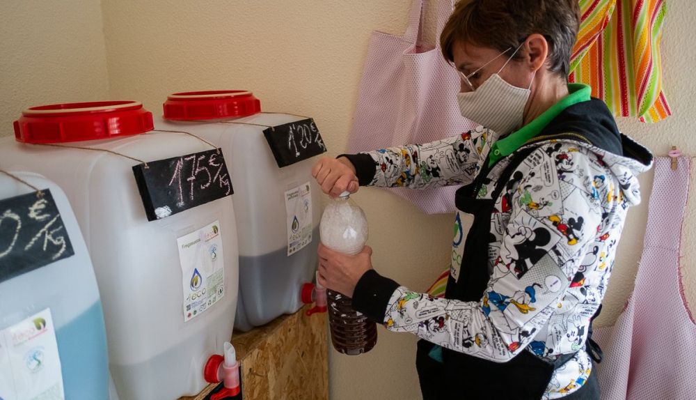 La encargada de 4Eco rellenando un envase reciclado con friegasuelos.