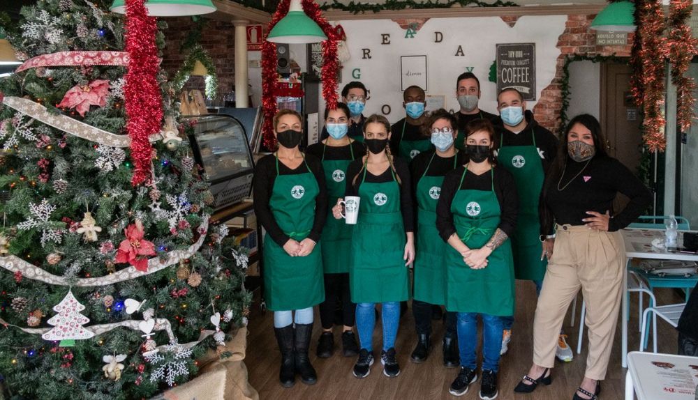 Equipo de Great Day Coffee en el interior decorado para Navidad.