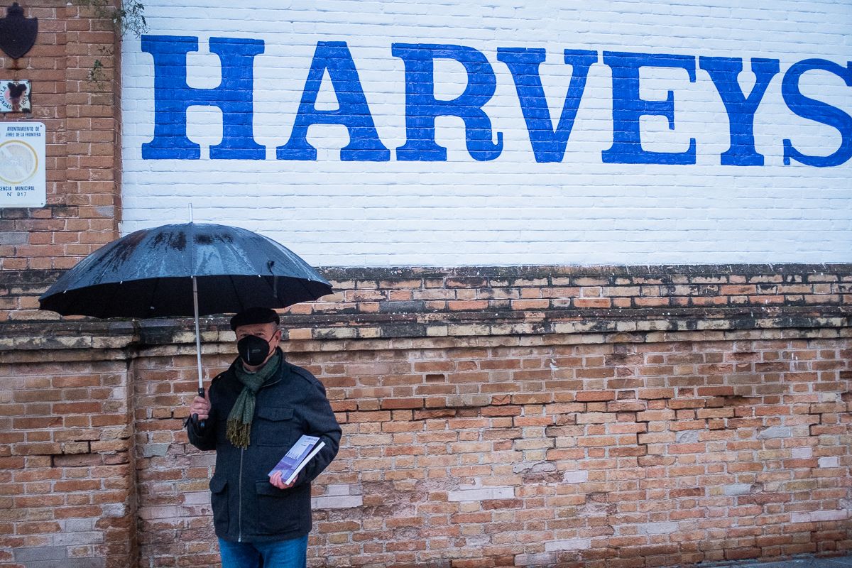 Manuel Fernández, con su libro frente a un letrero de Harveys, en la bodega de la avenida de Arcos.