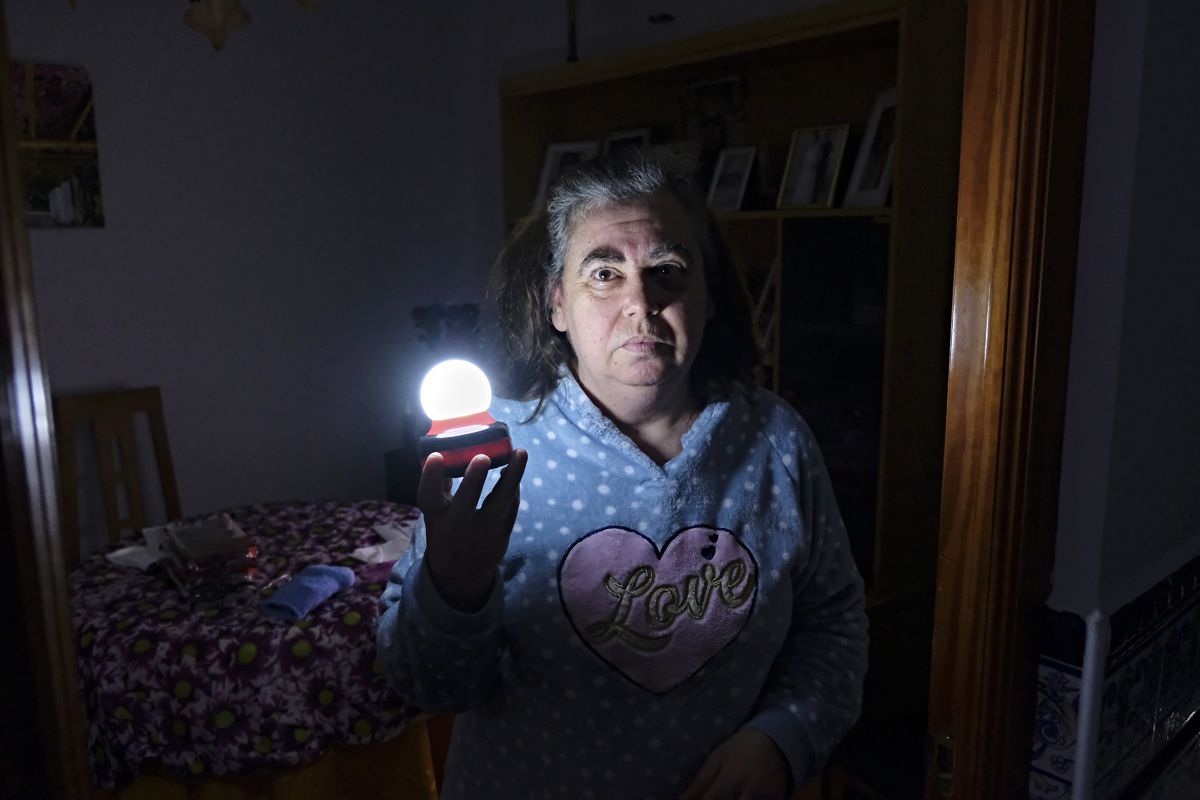 Trini, vecina de Su Eminencia, muestra la luz con la que se ilumina en las noches de cortes.