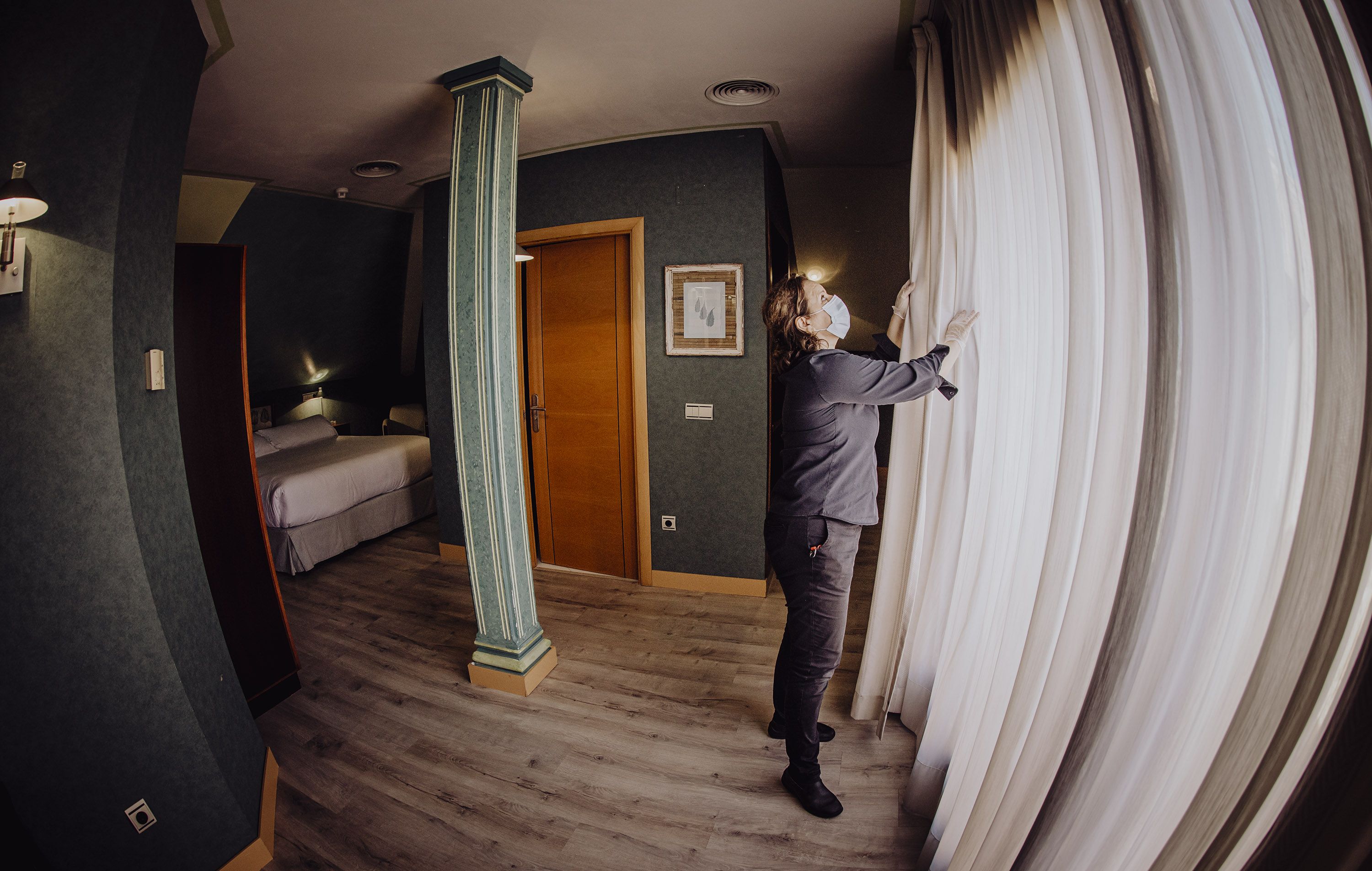 Una camarera de piso trabaja en la reapertura de una habitación de hotel en la pandemia.