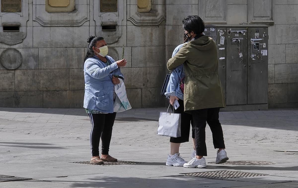 Ofrecimiento de una ramita de romero a una pareja de turistas.
