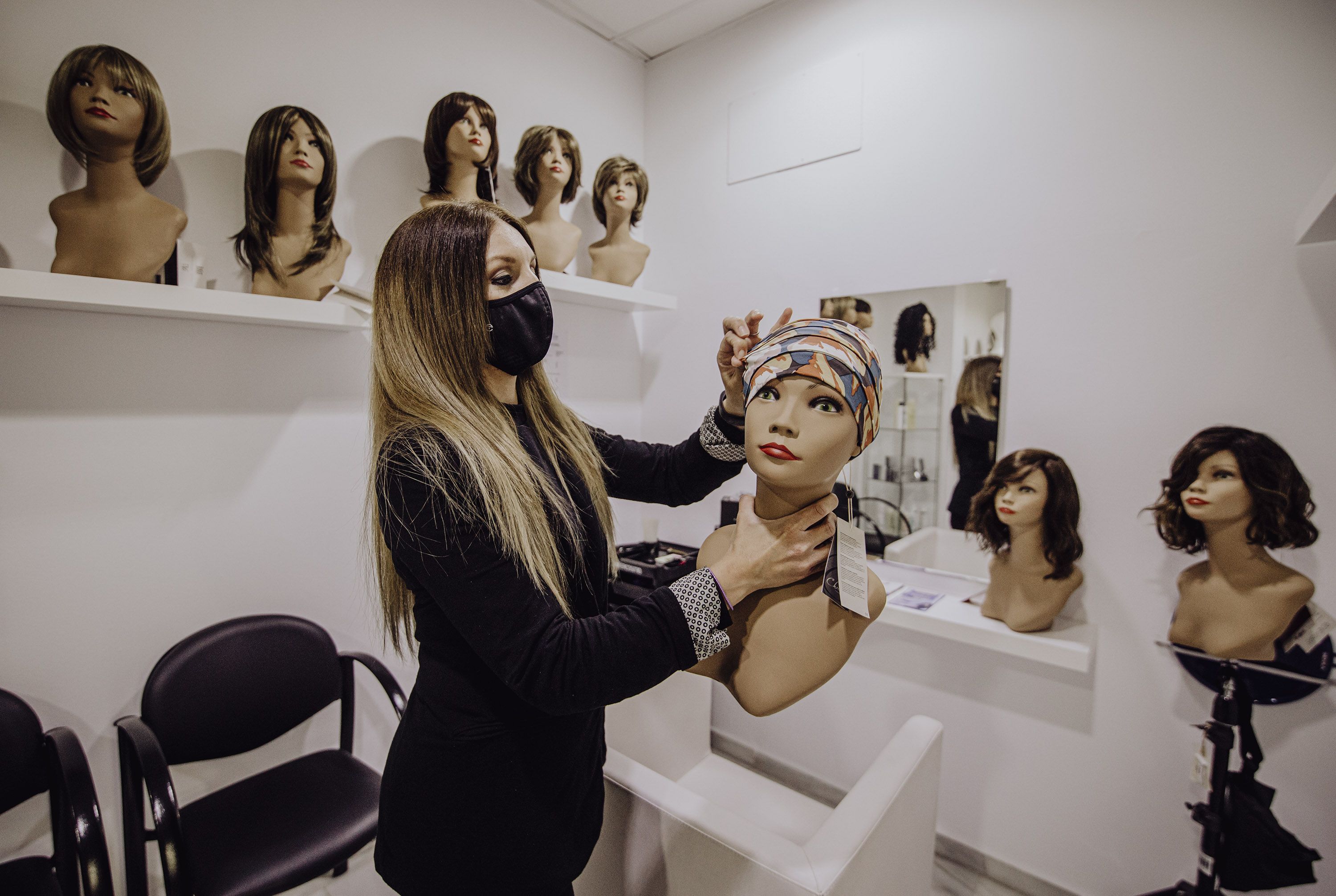 Elisabeth colocando un turbante a un maniquí.
