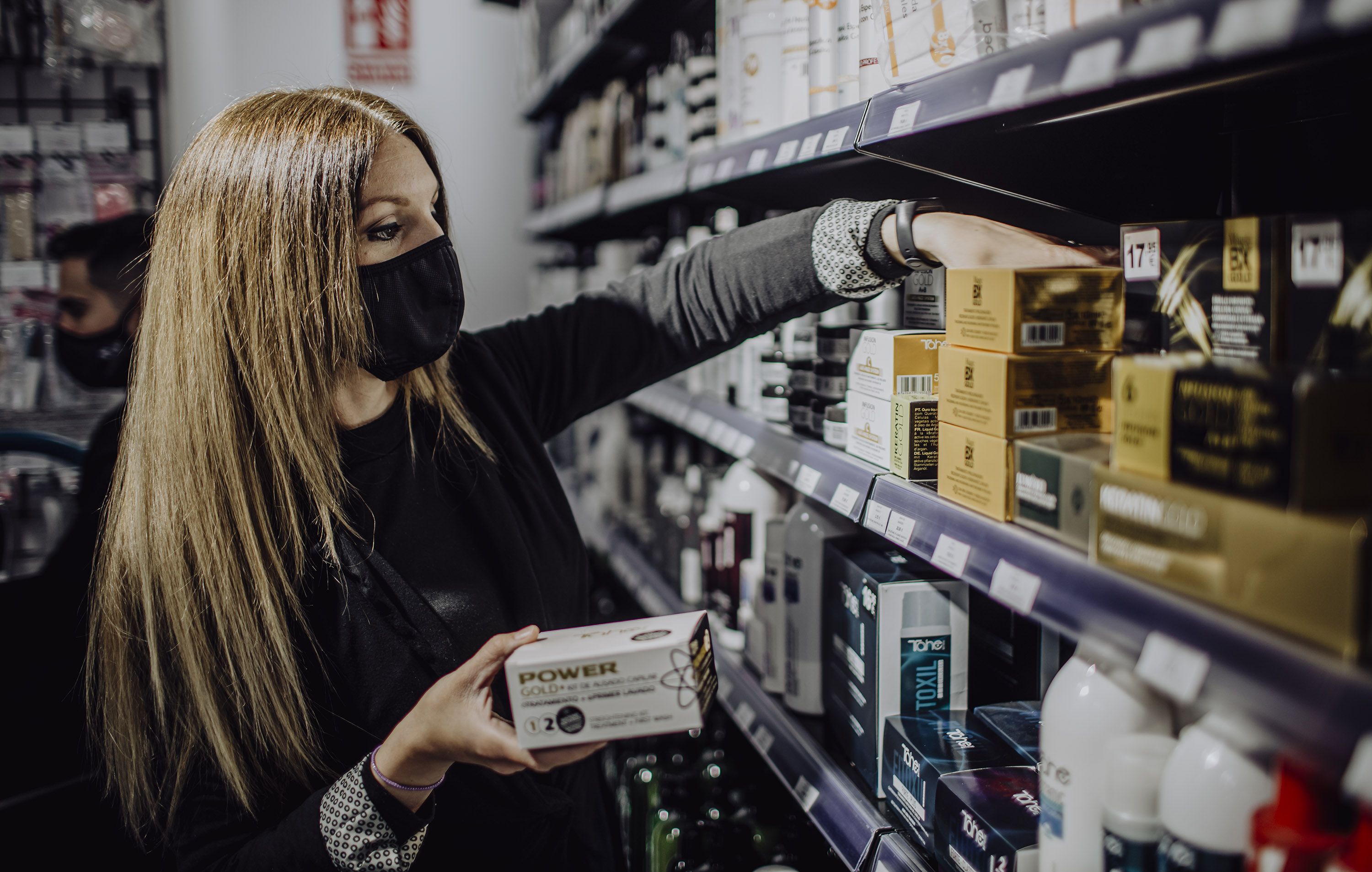 Elisabeth colocando algunos productos en la estantería.