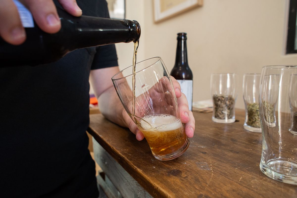 Israel llenando un vaso con cerveza Artemisa.