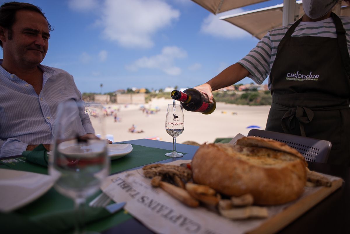 Una copa de vino en la terraza, con la muralla al fondo.