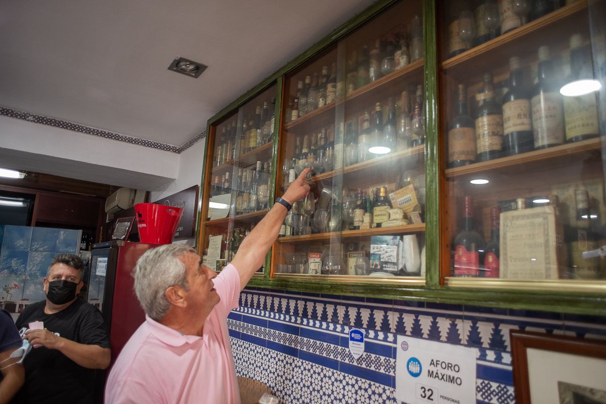 Ignacio frente a la vitrina de vinos antiguos.