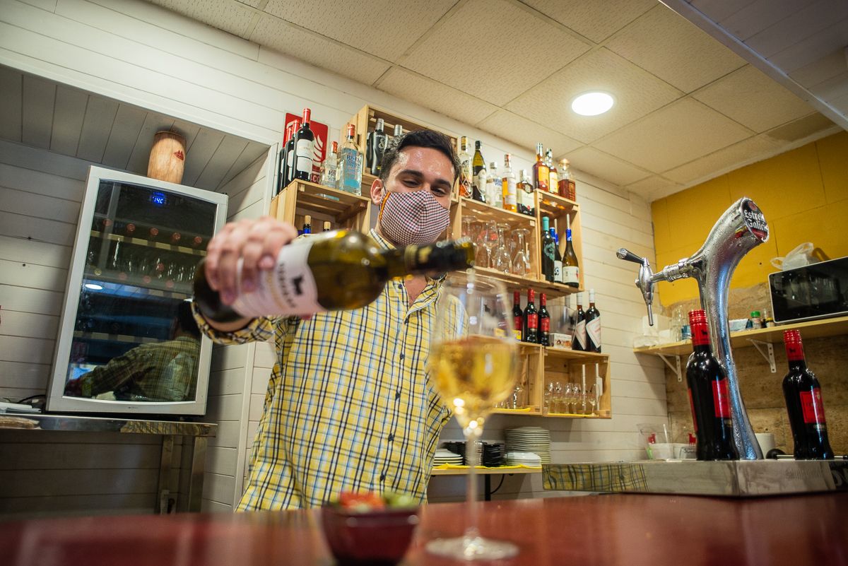 Alfonso prepara una copa de vino fino en la barra.