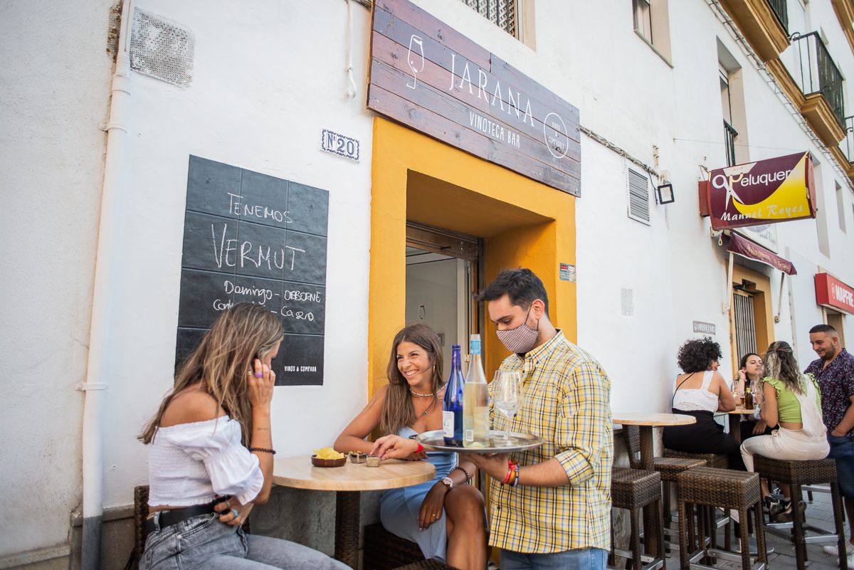 El portuense atiende a dos clientas de la terraza.