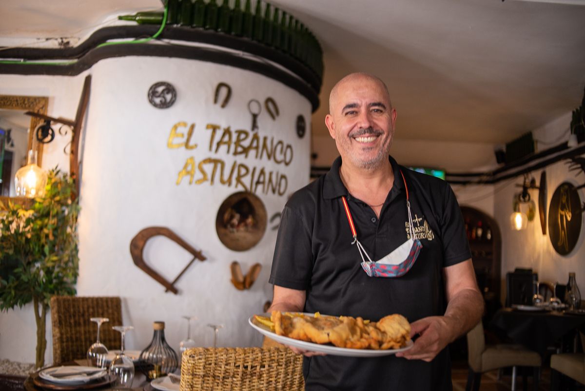 El dueño en el interior del tabanco con un plato de cachopo.