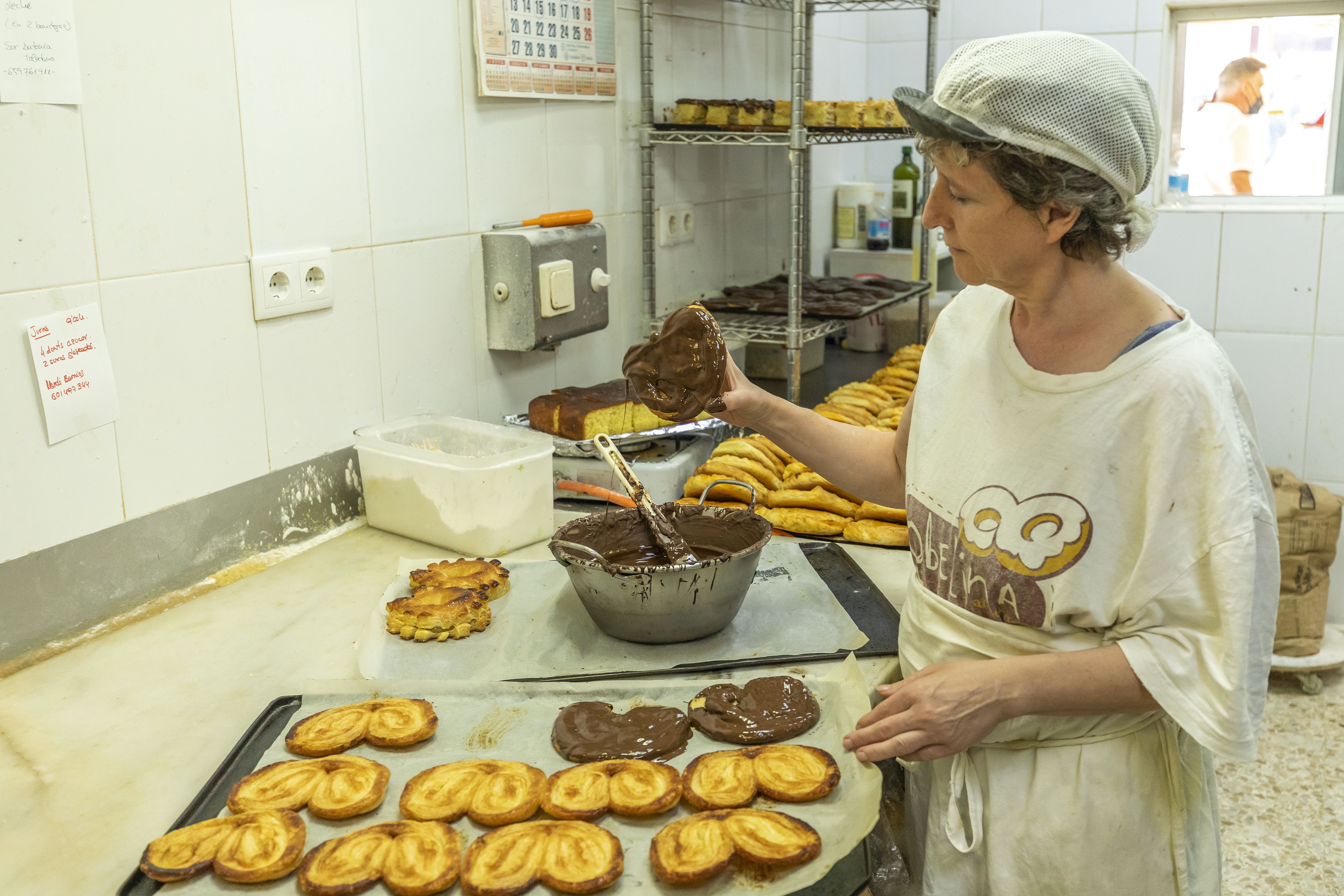 Una pastelera elaborando palmeras de chocolate.
