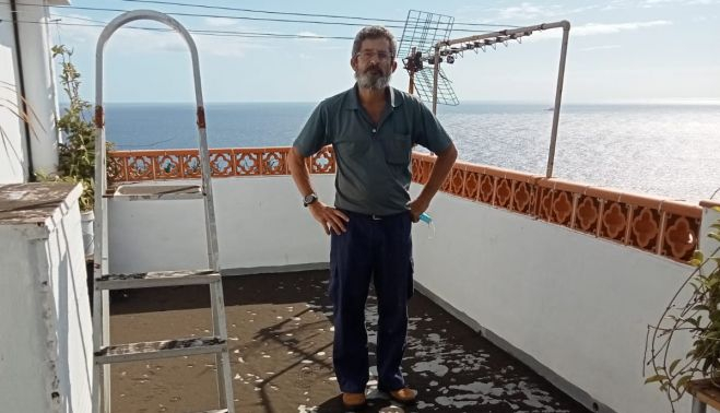 Carlos Robles, desde la terraza de su casa, con el suelo lleno de cenizas.