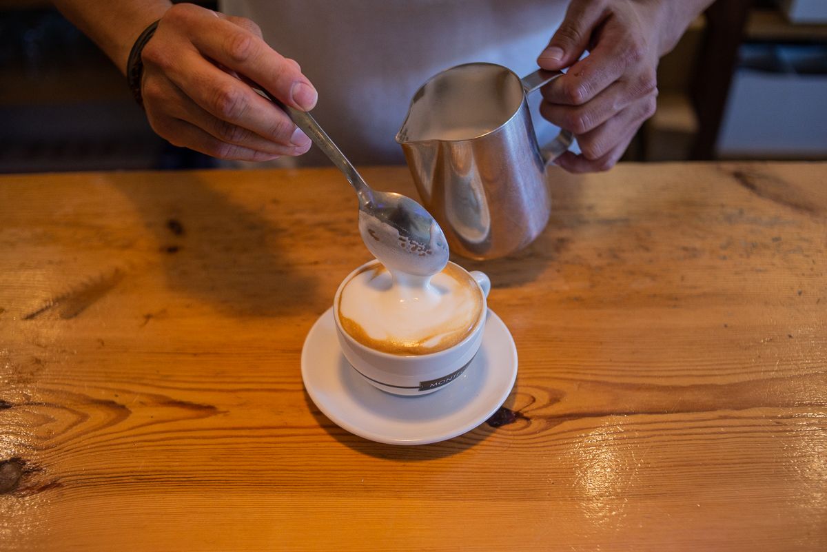 El colombiano vierte la leche en la taza.