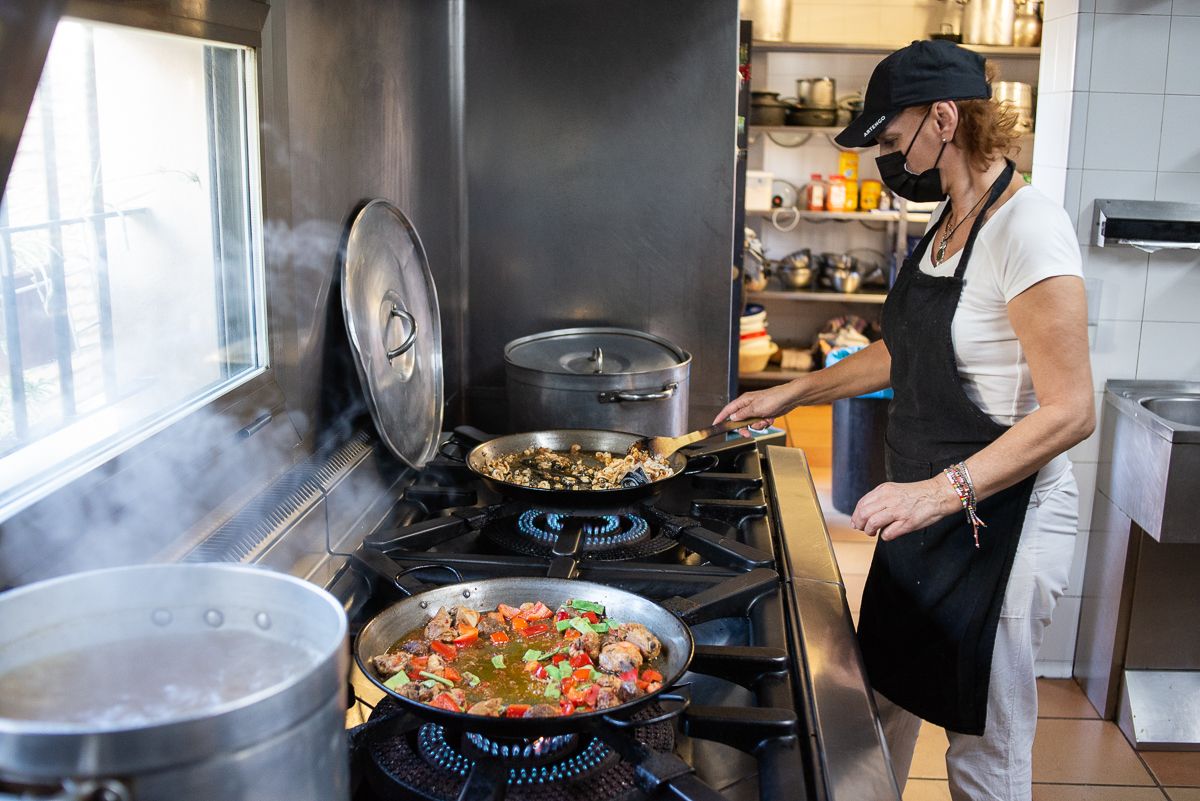Milagri cocinando la paella en los fogones.