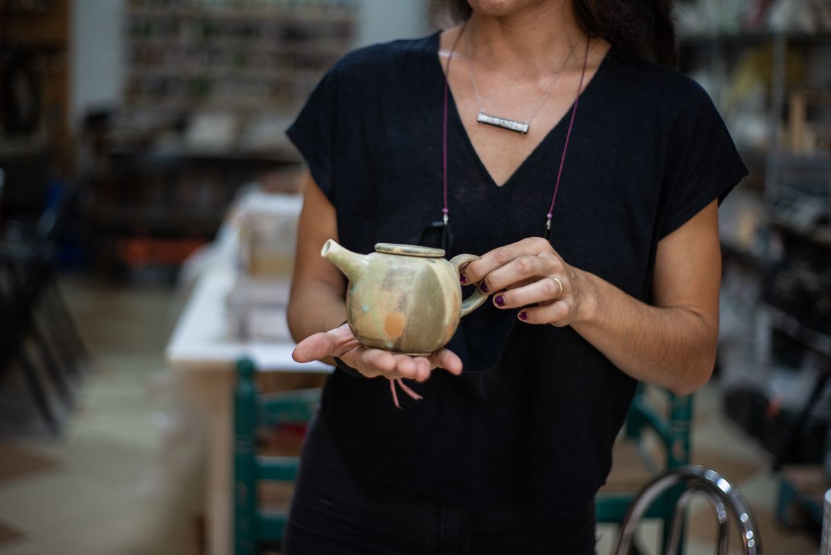 La artesana muestra una tetera.