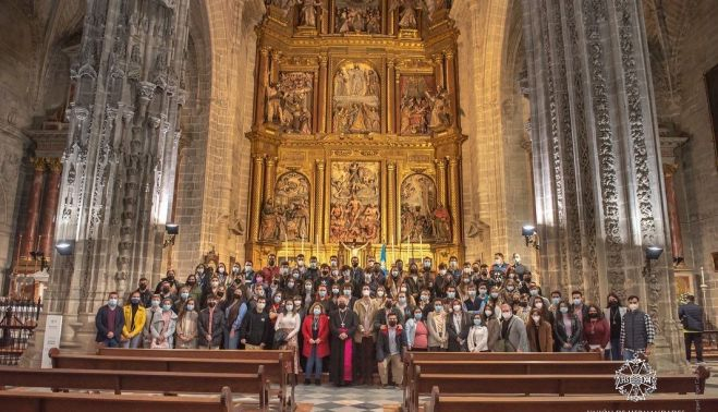 Los asistentes al encuentro, rodeando al obispo, ante el altar mayor de San Miguel