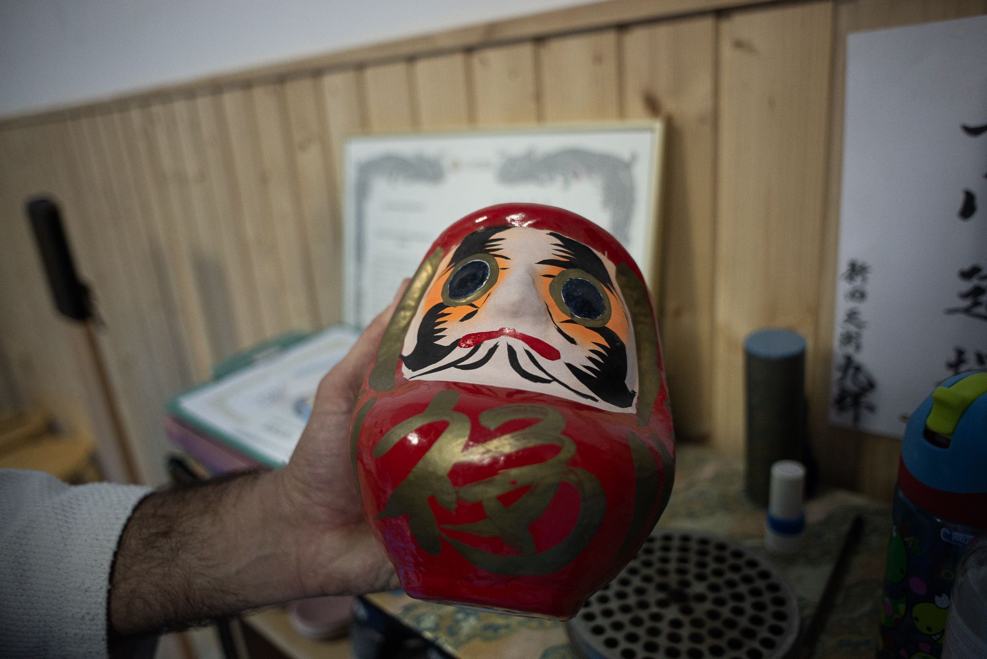 El maestro enseña el Daruma.
