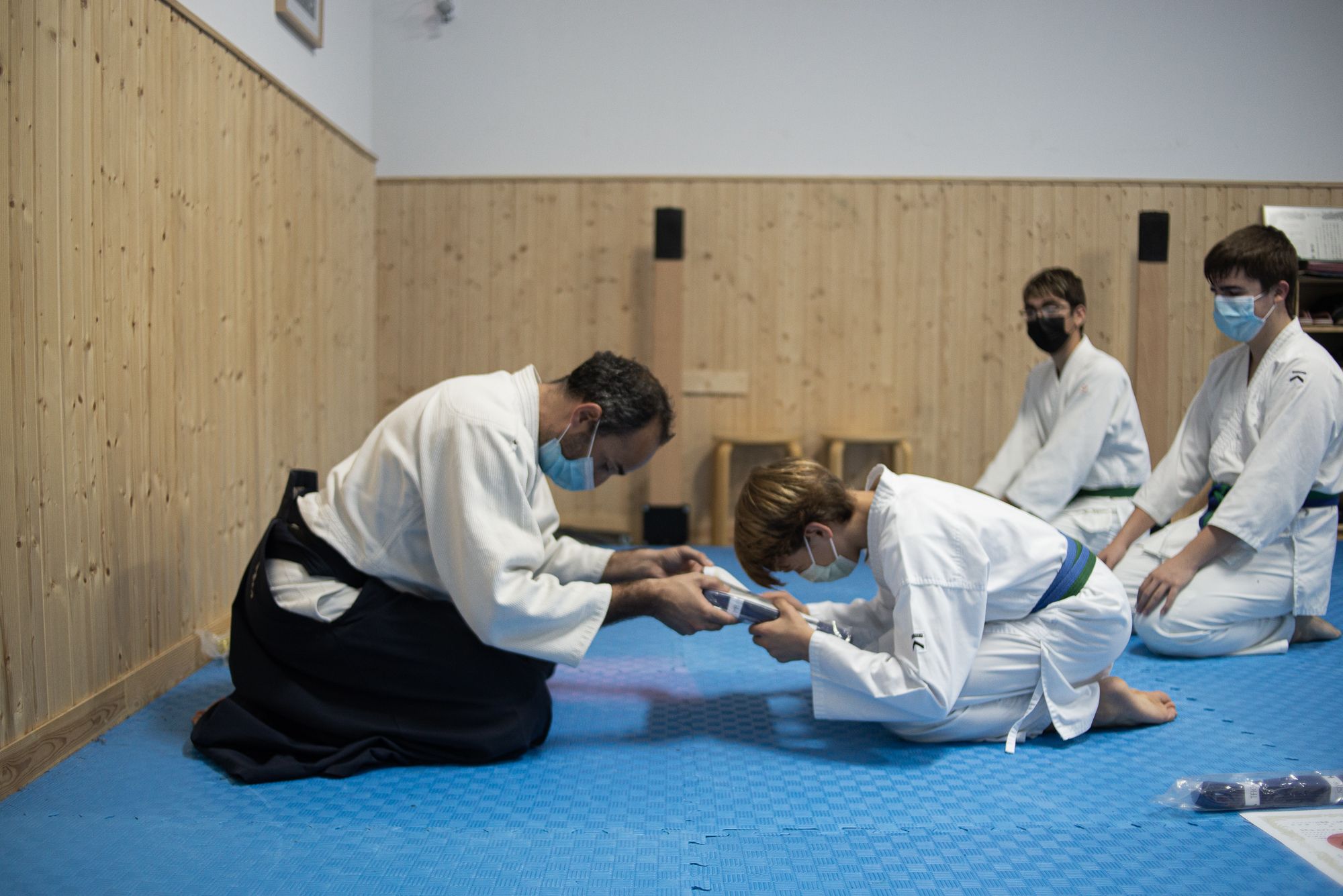 Un alumno recoge su diploma en el dojo.