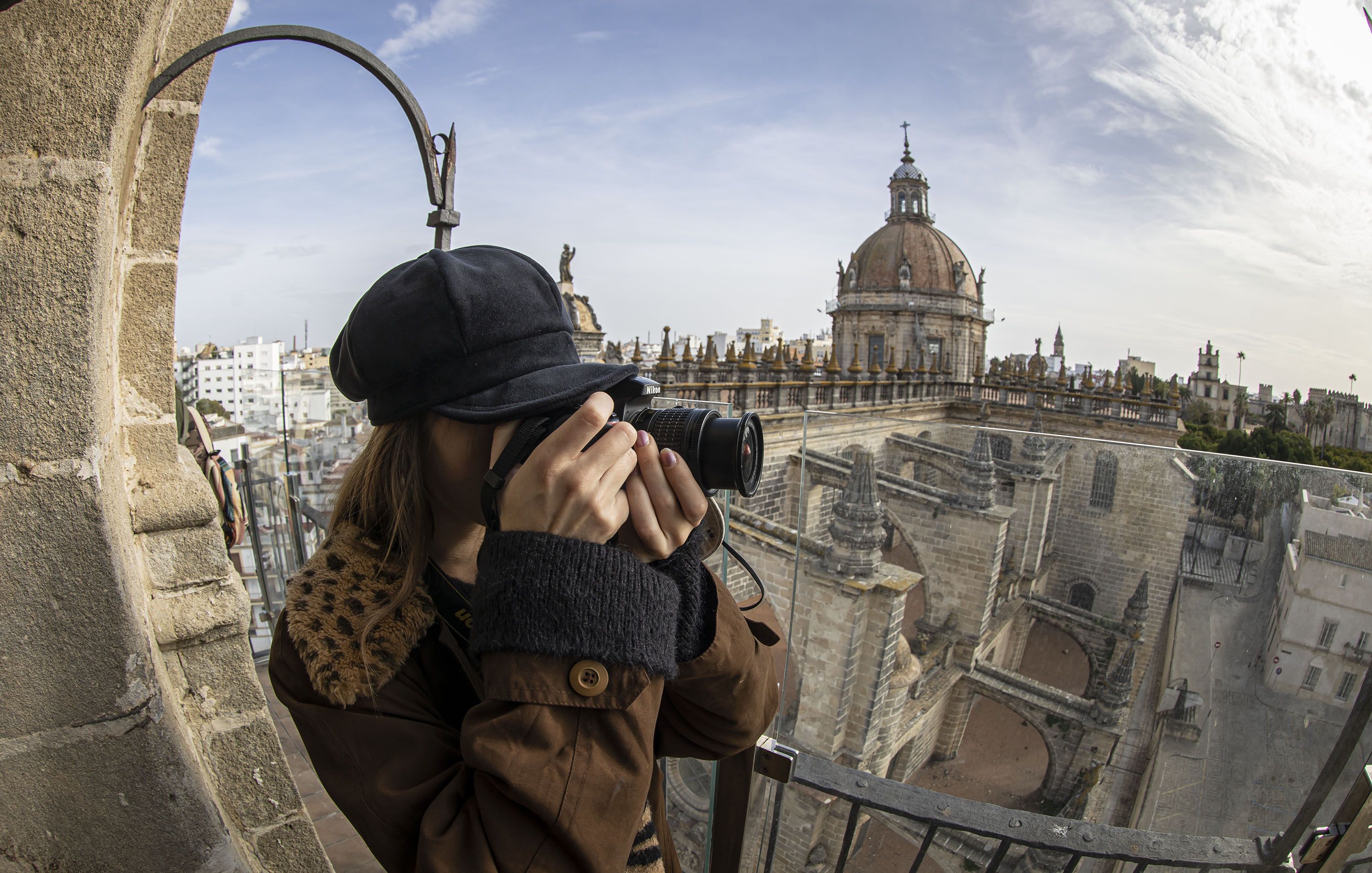 Una mujer toma fotos desde lo alto de la torre-campanario.