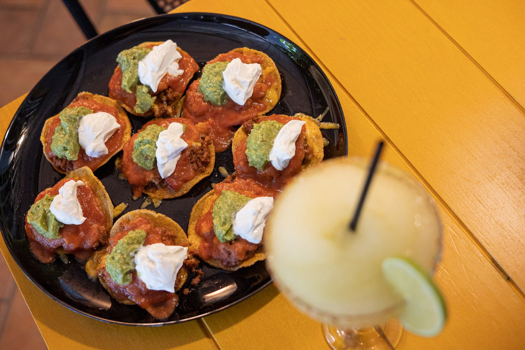 Plato de nachos completos con margarita.