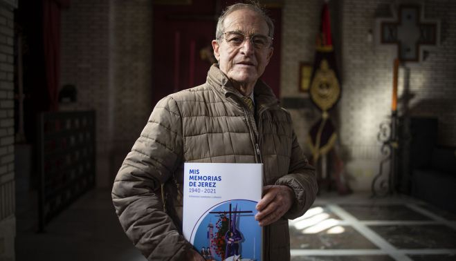 El autor posando con su libro ante el estandarte de su Hermandad de la Defensión.   ESTEBAN