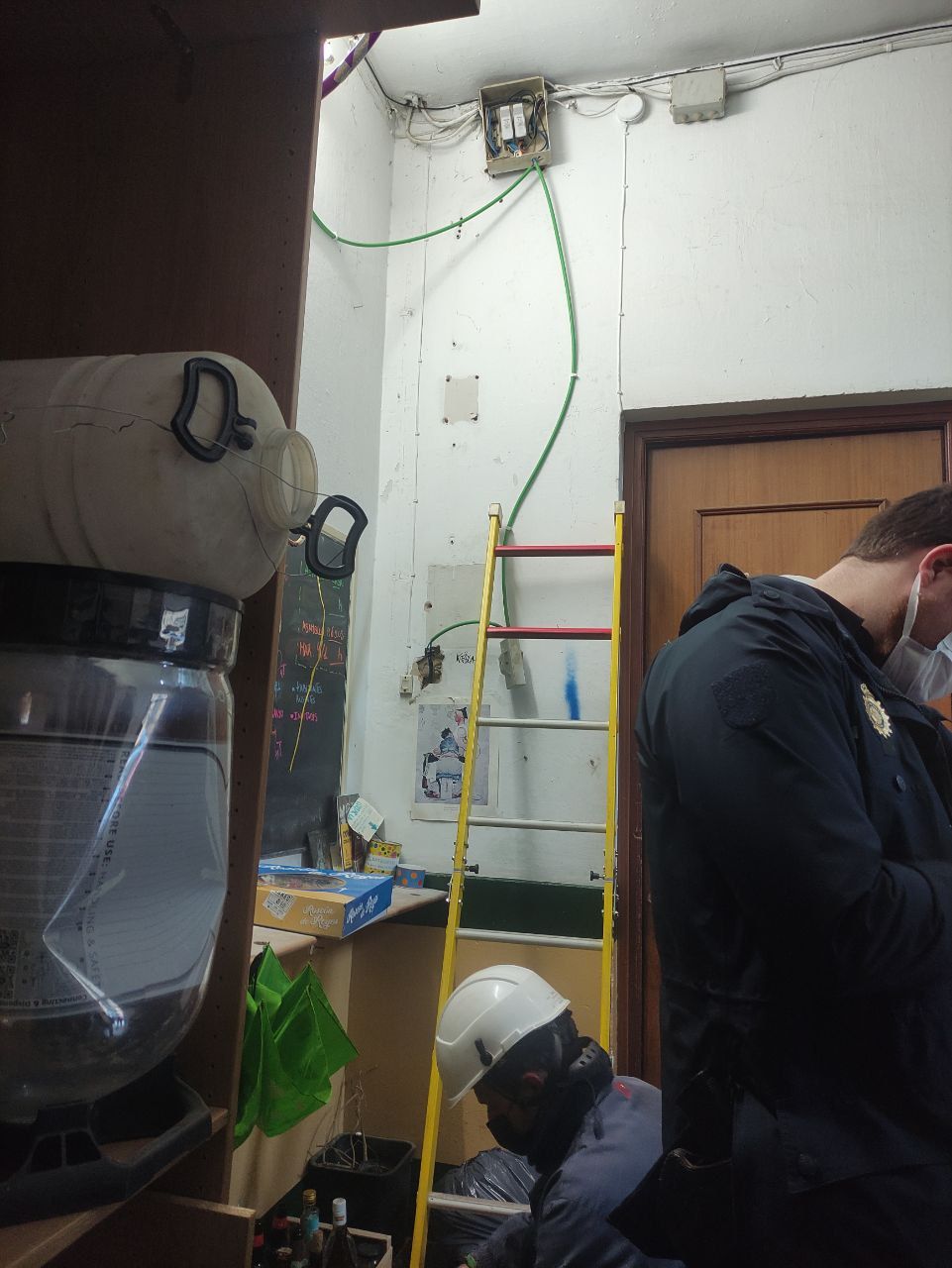Un agente de policía facilita el acceso al electricista que va a proceder al corte del suministro eléctrico.